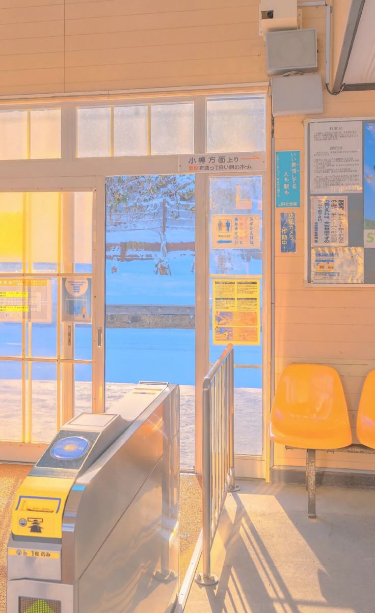 Photograph of a train station near a beach and the sea with a pale yellow, white, and blue filter. 